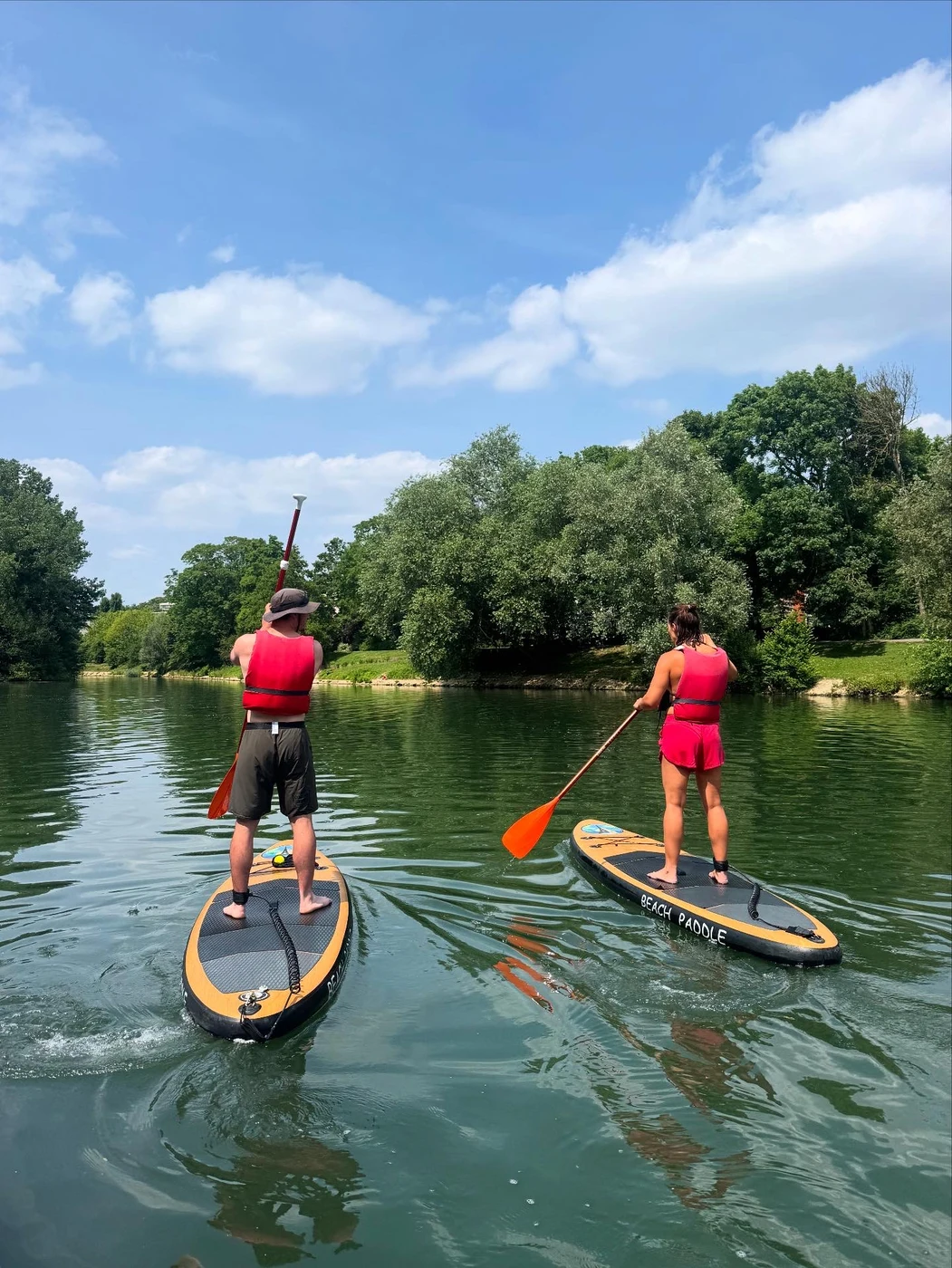 Deux paddlers s'éloignant sur la Marne verdoyante